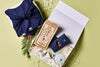 Gift box with tea packaging and decorative items on a light green background